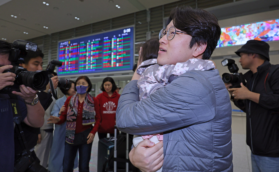 A father hugs his daughter, just returning from a short-term visit to Israel, at the Incheon International Airport on Wednesday. She was among 192 Koreans who flew out of Israel on the first direct flight to Korea since the attack by the Hamas militant group on Saturday. [NEWS1] 