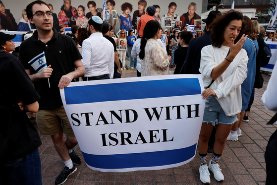 Protesters including Israelis residing in Japan, hold ″Stand-with-Israel″ rally demanding immediate release of all hostages captured during the ongoing conflict with Hamas, in front of Shibuya station in Tokyo, Japan, on Wednesday. [REUTERS/YONHAP]