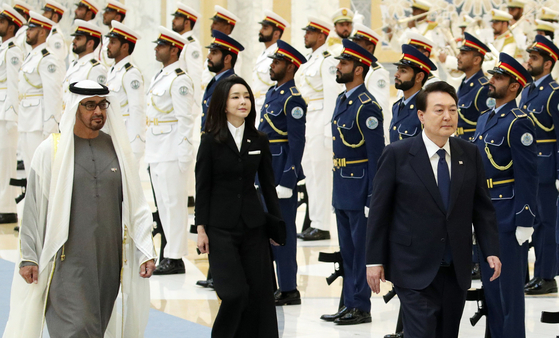 President Yoon Suk Yeol, right, and United Arab Emirates (UAE) President Mohammed bin Zayed Al Nahyan, left, accompanied by first lady Kim Keon Hee, center, view an honor guard during an official welcome ceremony during their bilateral summit on Jan. 15 in Abu Dhabi. [JOINT PRESS CORPS]