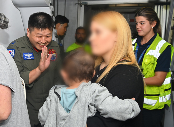 A Korean military official greets a young passenger that were boarding the Korean military aircraft KC-330 at the Ben Gurion Airport on Friday  [MINISTRY OF DEFENSE]