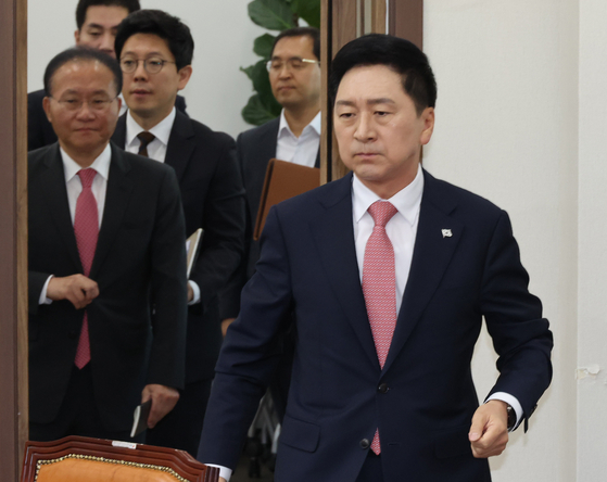 People Power Party (PPP) Chairman Kim Gi-hyeon, right, heads into a supreme council meeting Monday as the party named replacements after senior officials, including its secretary general, resigned Saturday to take responsibility for its election defeat in Gangseo District. [YONHAP] 