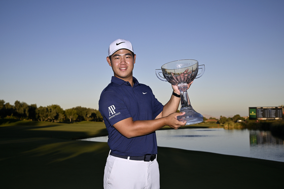 Tom Kim, also known as Kim Joo-hyung, poses with the trophy after putting in to win on the 18th green during the final round of the Shriners Children's Open at TPC Summerlin in Las Vegas, Nevada on Sunday.  [GETTY IMAGES]