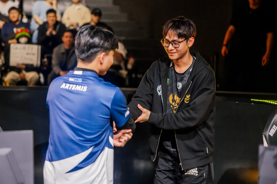 Quoc Hung ″Artemis″ Tran of Team Whales, left, and Hai Trung “Palette” Nguyen of GAM Esports shake hands onstage after competing at the 2023 League of Legends World Championship Play-Ins on Sunday in central Seoul. [RIOT GAMES]