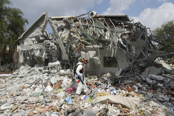 An Israeli soldier walks past a house destroyed by Hamas militants in Kibbutz Be'eri, Israel, on Oct. 11. [AP/YONHAP]
