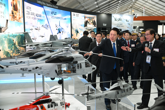 President Yoon Suk Yeol, front left, visits a booth for the Korea Aerospace Industries (KAI), as KAI CEO Kang Goo-young, front right, briefs him on the latest aircraft during the Seoul International Aerospace & Defense Exhibition (ADEX) at Seoul Air Base in Seongnam, Gyeonggi, Tuesday. [PRESIDENTIAL OFFICE]