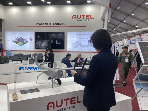 An employee at aerial robotics company Autel Robotics based in the U.S. demonstrates a drone at the company booth at the Seoul ADEX 2023 in Seongnam, Gyeonggi, on Tuesday. [CHO JUNG-WOO] 