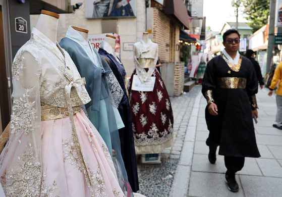 Foreign travelers pass by a hanbok, traditional Korean dress, rental shop near Gyeongbok Palace in Jongno District, central Seoul, on Sunday. [NEWS1]