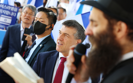 Israel's Ambassador to Kore Akiva Tor repeats the words of the rabbi, right, as he reads aloud from the book of Psalms during the rally in Seoul on Tuesday. [YONHAP] 