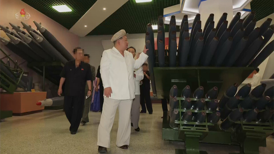 North Korean leader Kim Jong-un examines the 122-millimeter shell used in its multiple rocket launchers on Aug. 7 during a tour of an ammunition production plant. [KOREAN CENTRAL NEWS AGENCY] 