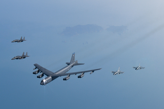 A U.S. B-52 strategic bomber flies at the front of a formation with F-15K Slam Eagle strike fighters and KF-16 fighter jets above the West Sea during a joint drill on March 6. [DEFENSE MINISTRY]  