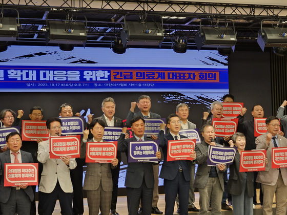 Members of the Korean Medical Association (KMA) declare that they will take “strong action” if the government pursues a policy to expand medical school enrollment quota to address doctor shortages in the country after holding an emergency meeting in Yongsan District, central Seoul, Tuesday evening. The KMA threatened to hold a large-scale strike if the government follows through with the plan, and members hold up signs reading that if the quota is increased, “the medical system will collapse.” [YONHAP]