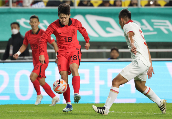 Korea's Lee Kang-in, left, dribbles the ball during a friendly with Vietnam at Suwon World Cup Stadium in Suwon, Gyeonggi on Tuesday. [YONHAP]