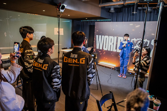 Chinese-owned JD Gaming's Park ″Ruler″ Jae-hyuk, who was part of the Korean gold medal winning team at the Hangzhou Asisan Games in September, gives an interview while members of Korea's Gen.G watch at LoL Park in central Seoul on Monday. [RIOT GAMES]