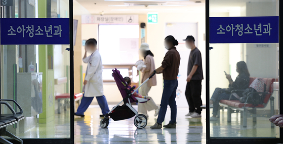  Patients and guardians waits at Kyungpook National University Hospital’s pediatric department in Daegu on Thursday. There have been concerns over the lack of essential medical services and professions especially in provincial areas outside the greater Seoul area. [YONHAP]  