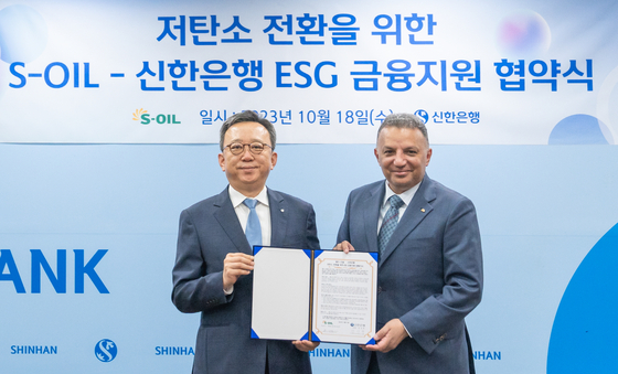 S-Oil CEO Anwar A. Al-Hejazi, right, and Shinhan Bank CEO Jung Sang-hyuk pose for a photo during a signing ceremony held at Shinhan Bank headquarters in Jung District, central Seoul, on Wednesday. [S-OIL]