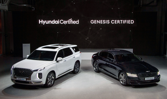 A secondhand Palisade SUV, left, and Genesis G80 that are ready to be resold are on display Thursday [HYUNDAI MOTOR]