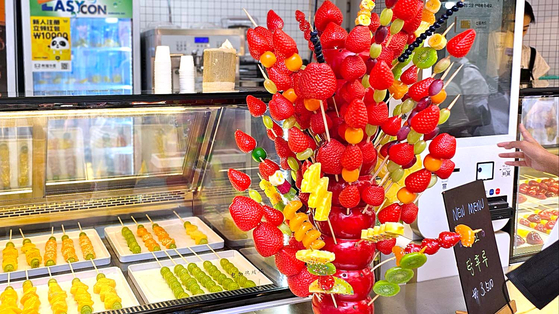 Tanghulu, a traditional Chinese dessert created by skewering assorted fruits coated with a layer of sugary syrup, are on display at a store in Mapo District, western Seoul, on Oct. 10. [JOONGANG PHOTO]