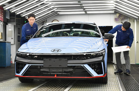 Hyundai Motor employees inspect Avante N at the company's manufacturing plant in Ulsan on Wednesday. [HYUNDAI MOTOR]