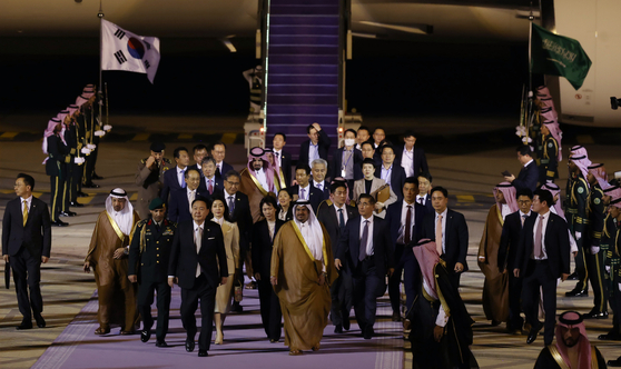 Korean President Yoon Suk Yeol, third from left, first lady Kim Keon Hee and the presidential entourage arrive on Air Force One, escorted by Saudi fighter jets, at King Khalid International Airport in Riyadh for a state visit to Saudi Arabia on Saturday evening. They were greeted by an honor guard and Saudi officials, including Prince Mohammed bin Abdulrahman bin Abdulaziz, deputy governor of Riyadh. [JOINT PRESS CORPS]