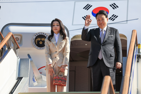 President Yoon Suk Yeol, right, accompanied by first lady Kim Keon Hee, waves before boarding the presidential plane to head to Riyadh, Saudi Arabia, for a six-day trip which will also take him to Qatar from the Seoul Air Base in Seongnam, Gyeonggi, Saturday. [PRESIDENTIAL OFFICE] 