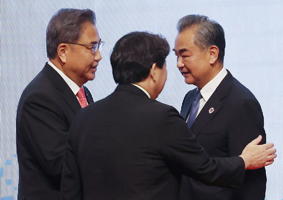 In this file photo dated Aug. 4, the foreign ministers of Korea, Japan and China greet each other during the Aesan Plus Three forum in Phnom Penh, Cambodia. From left, Foreign Minister Park Jin, Japanese Foreign Minister Yoshimasa Hayashi and Chinese Foreign Minister Wang Yi. Korea is expected to host trilateral foreign ministerial and presidential summits before the end of the year. [NEWS1]