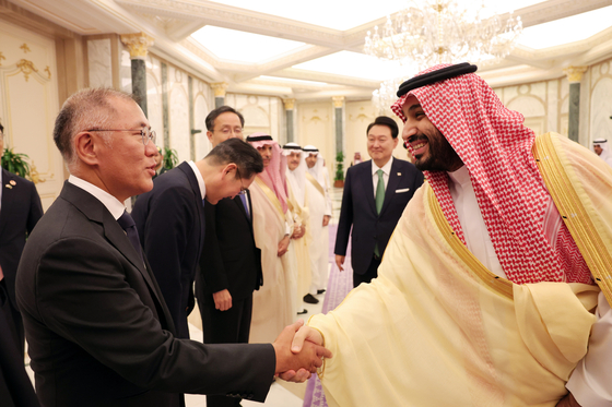 Hyundai Motor Group Executive Chair Euisun Chung, left, shakes hands with Saudi Arabia's Crown Prince and Prime Minister Mohammed bin Salman at the Al Yamamah Palace in Riyadh on Sunday. [YONHAP]