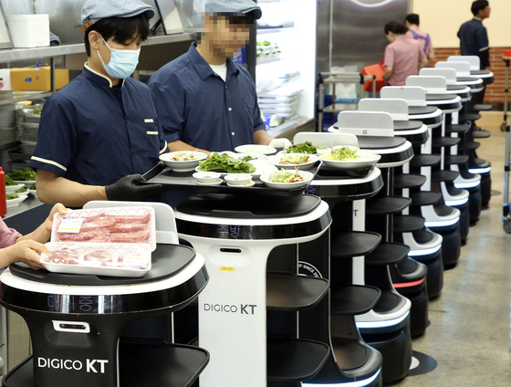 AI serving robots are getting ready to deliver food at a restaurant in Wanju District, North Jeolla. [YONHAP]