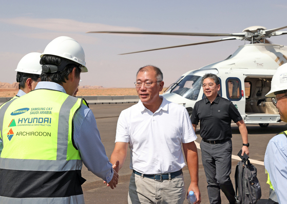 Hyundai Motor Group Executive Chair Euisun Chung shakes hands with a Hyundai Engineering & Construction employee during his visit to the construction site of a tunnel at The Line, a residential area of Saudi Arabia’s mega-project NEOM, on Monday. [HYUNDAI MOTOR]