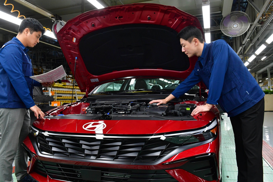 Hyundai Motor workers inspect Elantra sedan at the company's Ulsan plant last week. [HYUNDAI MOTOR] 