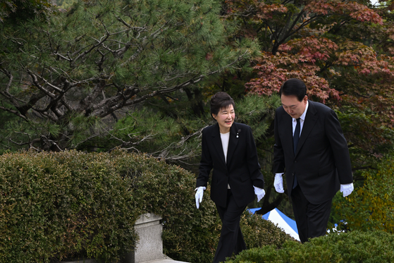 Former President Park Geun-hye, left, and President Yoon Suk Yeol at the Seoul National Cemetary on Thursday where Park's father and late President Park Chung Hee is buried. Thursday marked the 44th anniversary since the late president was assassinated. [PRESIDENTIAL OFFICE] 