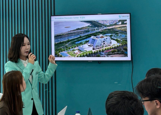 Prestige Biopharma CEO Park So-yeon speaks during a press conference held on Tuesday during the CPHI Worldwide 2023 in Barcelona, with an image of the company's upcoming R&D center displayed on screen. [PRESTIGE BIOPHARMA]