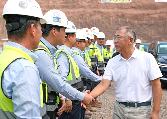 Hyundai Motor Group Executive Chair Euisun Chung shakes hands with a Hyundai Engineering & Construction employee during his visit to the construction site of a tunnel at The Line, a residential area of Saudi Arabia’s mega-project NEOM City, on Monday. [HYUNDAI MOTOR]