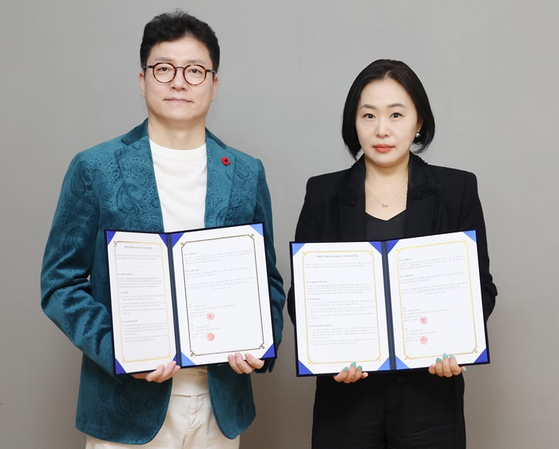 Oscar Chun, CEO of Attrakt, left, and Lee Kyung-ran, CEO of Studio Jamm, signed a memorandum of understanding to produce a new K-pop audition program on JTBC on Friday. [ATTRAKT]
