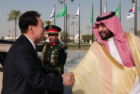 Korean President Yoon Suk Yeol, left, shakes hands with Saudi Crown Prince Mohammed bin Salman ahead of their bilateral summit at the Al Yamamah Palace in Riyadh last Sunday. [JOINT PRESS CORPS]
