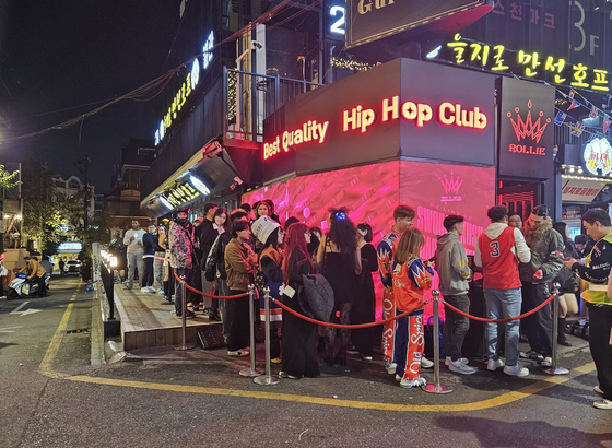 People lined up in front of a store in Hongdae on Saturday with some dressed up for Halloween. [LEE YOUNG-KEUN]