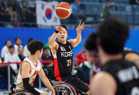 Korea's Cho Seung-hyun passes the ball during the men's wheelchair basketball gold medal match against Japan at the 4th Asian Para Games in Hangzhou, China on Friday. [XINHUA]
