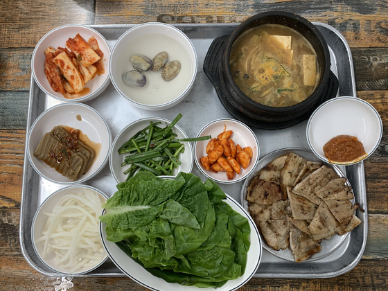 Doenjang jjigae (fermented soybean stew) and pork barbecue along with various side dishes, at Seongbukdong Pork Ribs in Seongbuk District, central Seoul [LEE JIAN]
