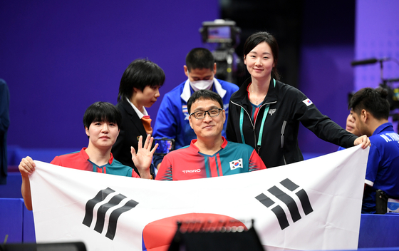 Korea's Jang Young-jin, left, and Joo Young-dae pose after winning the final of the MD 4 mixed doubles table tennis at the 4th Asian Para Games in Hangzhou China on Friday. [NEWS1]