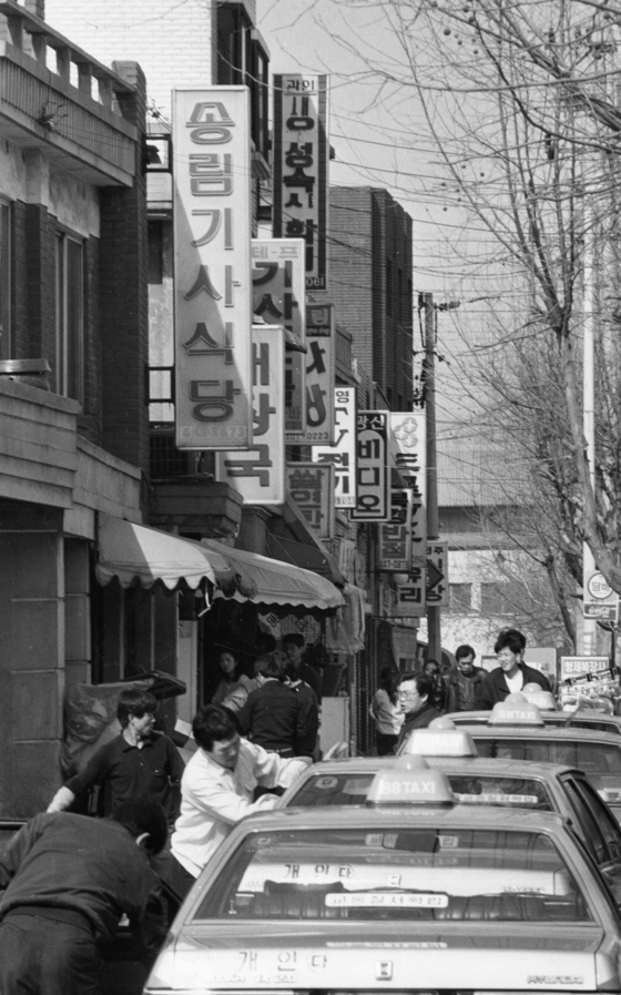 Taxis are lined up in front of a street full of gisa sikdang in Gwangjin District, eastern Seoul, in the 1980s. [JOONGANG PHOTOS]