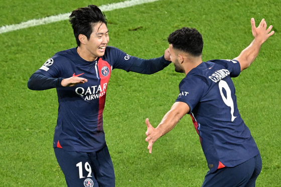 Paris Saint-Germain's Lee Kang-in, left, celebrates with Goncalo Ramos after scoring their third goal during a UEFA Champions League match against AC Milan at the Parc de Princes in Paris on Wednesday.  [AFP/YONHAP]