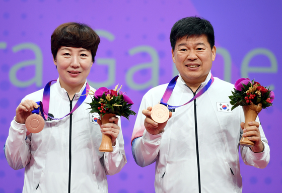 Kim Gun-hae, left, and Shin Seung-won pose with their medals after taking bronze in table tennis mixed doubles XD17-20 at the 4th Asian Para Games in Hangzhou, China on Thursday. [NEWS1]