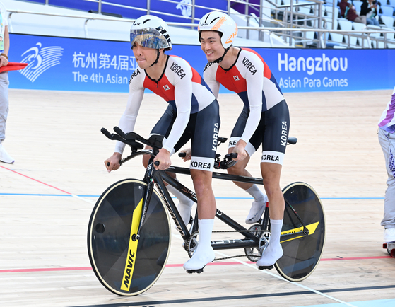 Korea's Kim Jung-been, left, competes with pilot Yang Joong-hun in men's cycling B at the 4th Asian Para Games in Hangzhou, China. [대한장애인체육회]