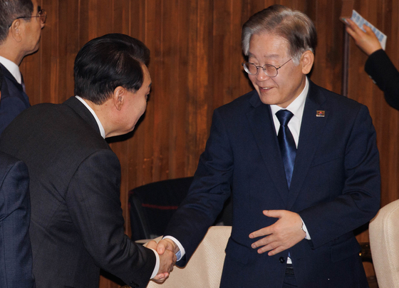 Democratic Party Chairman Lee Jae-myung, right, greets President Yoon Suk Yeol at the National Assembly in Yeouido, western Seoul on Tuesday. [JOINT PRESS CORPS]