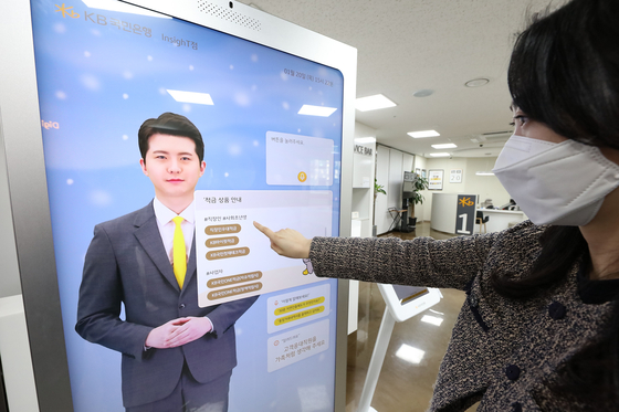 A customer taps on a kiosk featuring an AI digital agent at a KB Bank branch in Yeouido, western Seoul [KB BANK]
