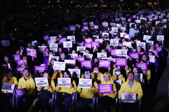 Bereaved families of the Itaewon crowd crush and participants of the rally commemorating the victims of the tragedy hold signs asking for the legislation of the Itaewon Disaster Special Act during a rally held in Seoul Plaza in central Seoul on Sunday