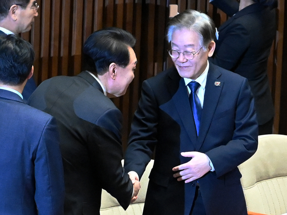 President Yoon Suk Yeol, left, shakes hand with Democratic Party Chairman Lee Jae-myung at the National Assembly in Yeouido, western Seoul, before making his parliamentary speech on next year’s budget on Tuesday. [JOINT PRESS CORPS]