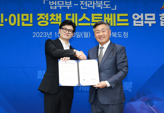 Justice Minister Han Dong-hoon, left, and North Jeolla Govenor Kim Kwan-young celebrates an agreement on cooperating on innovative immigration policies on Monday at the local government's office in Jeonju. [NORTH JEOLLA GOVERNMENT]