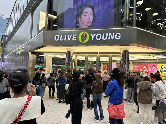 A lengthy queue forms in front of the two-story Olive Young Myeong-dong Town branch in central Seoul on Wednesday morning. Most of the people waiting were foreigners, gathered 10 minutes before the 10 a.m. opening time. The branch reopened Wednesday following a two-month renovation. [SEO JI-EUN]