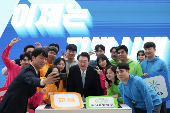 President Yoon Suk Yeol, center, poses for a photo with young people at a ceremony for local autonomy and balanced development at the Daejeon Convention Center in Daejeon Thursday. He also viewed booths at the 2023 Expo for Local Era which runs to Friday at the convention center. [PRESIDENTIAL OFFICE]