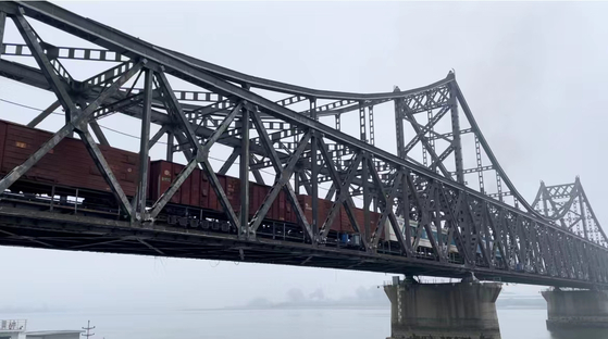A freight train crosses the Sino-Korean Friendship Bridge over the Yalu River that divided China and North Korea on Sept. 27, 2022. [YONHAP]